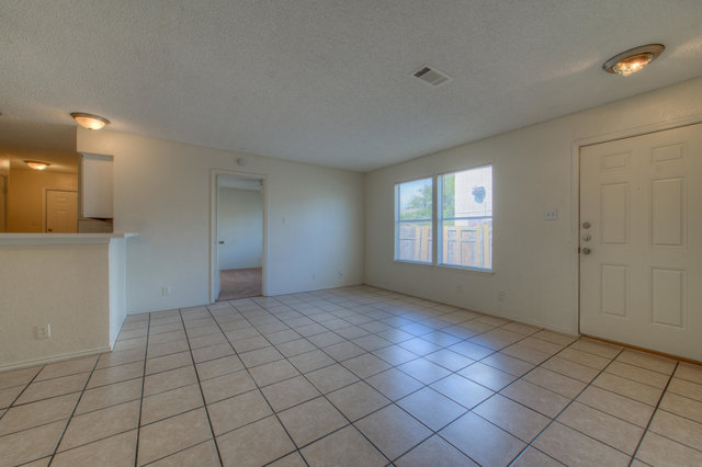 6906 Deep Circle, Unit B Austin, TX 78744 - Photo 6 of 19 Unfurnished living room featuring a textured ceiling and light tile patterned floors