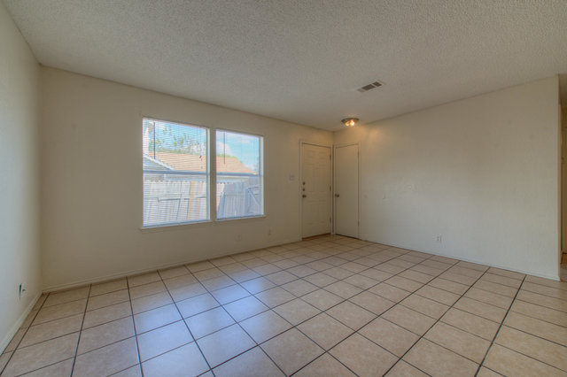 6906 Deep Circle, Unit B Austin, TX 78744 - Photo 7 of 19 Empty room featuring a textured ceiling and light tile patterned floors