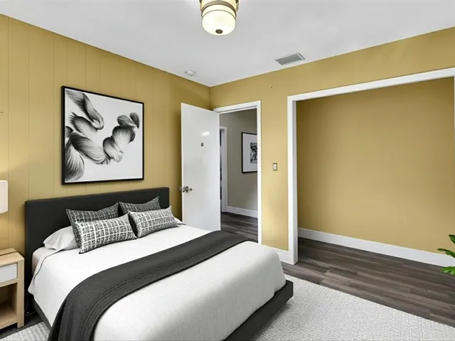 a bedroom with a bed and a painting on the wall