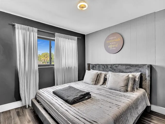 a bedroom with bed and wooden floor