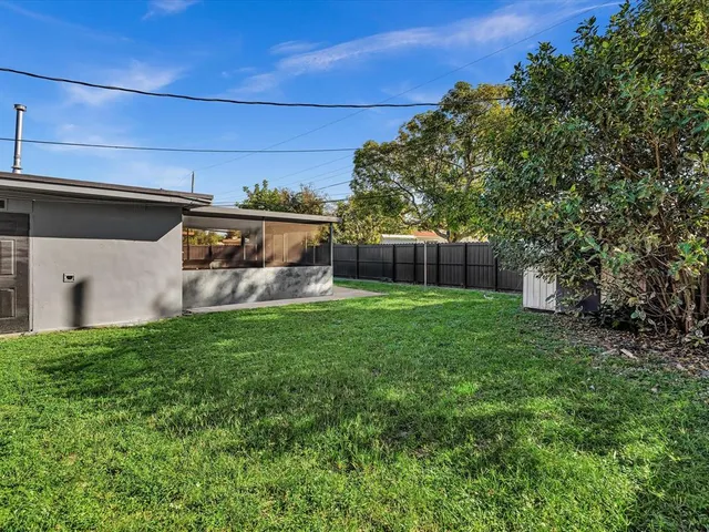 a view of house with backyard and a garden