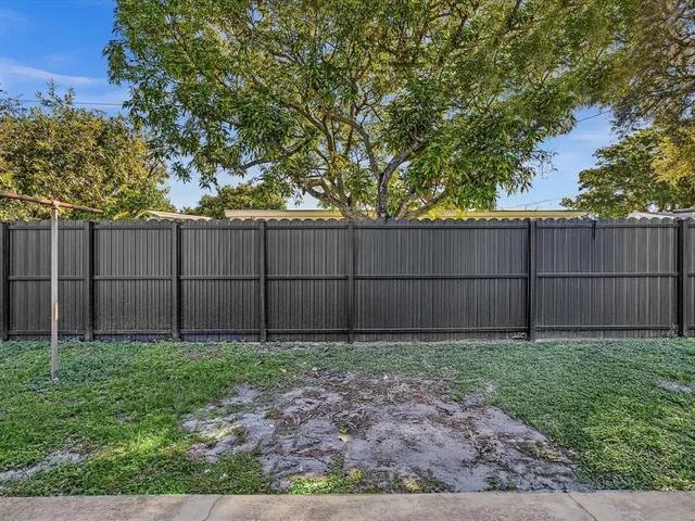 a view of backyard with wooden fence