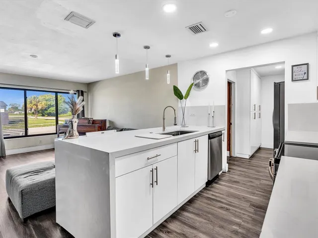 a large white kitchen with a large window