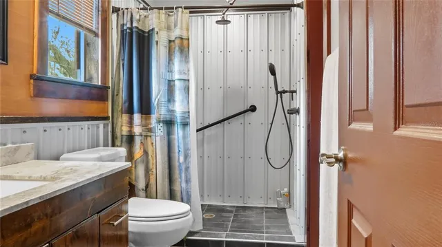a bathroom with a granite countertop sink toilet and shower