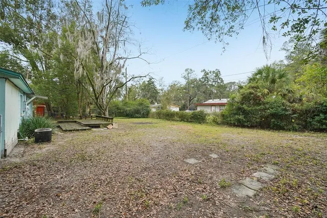 a view of backyard of house with green space