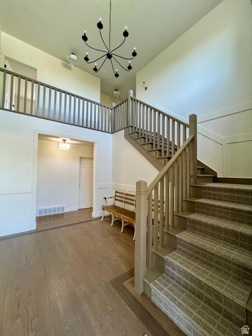 812 East Bates Cyn Road Tooele, UT 84074 - Photo 9 of 144 Two-story foyer featuring an open staircase with carpeted treads and painted balusters, a coordinating upper-level railing, and a black multi-arm chandelier