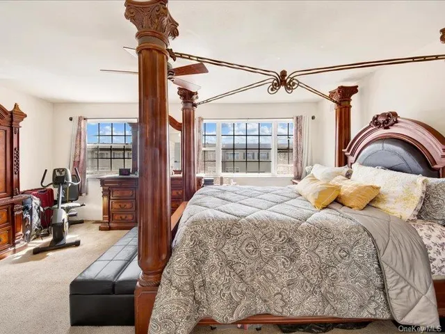 a bedroom with a bed couch and a large window