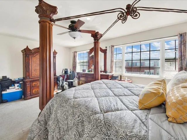 a bedroom with a bed next to a window and a chandelier