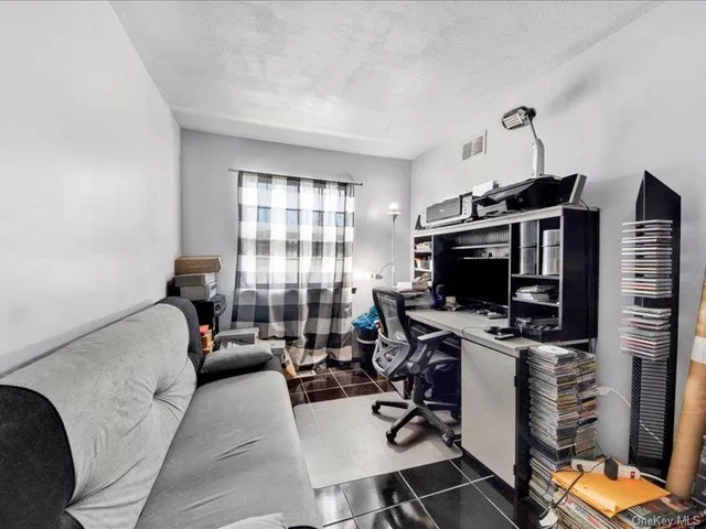 a view of a livingroom with workspace and a window