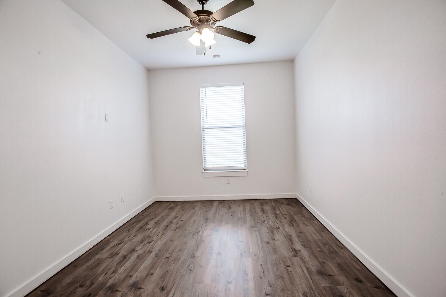 2535 138th Street Lubbock, TX 79423 - Photo 11 of 15 an empty room with wooden floor fan and windows