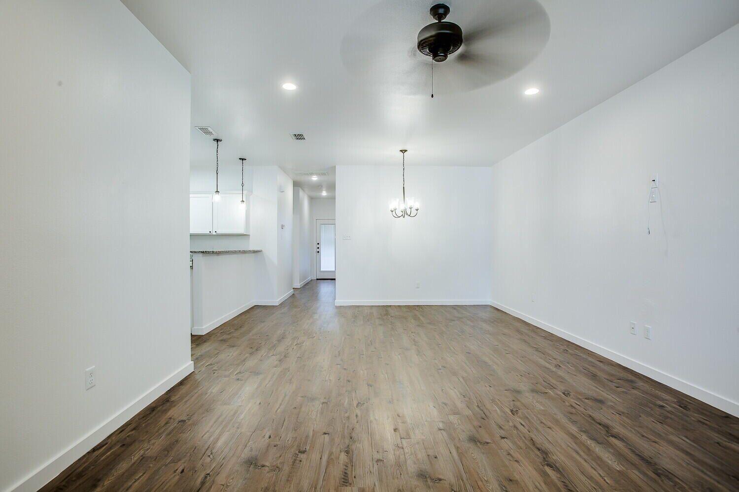 2535 138th Street Lubbock, TX 79423 - Photo 3 of 15 an empty room with wooden floor kitchen view and a window