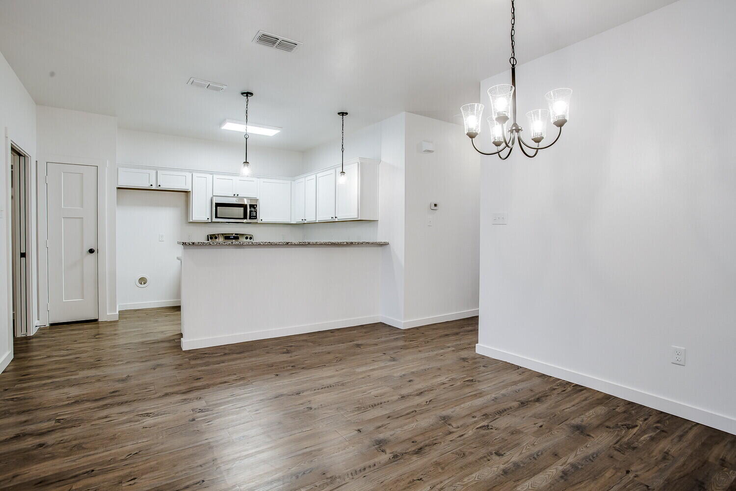 2535 138th Street Lubbock, TX 79423 - Photo 6 of 15 a view of a kitchen with a sink dishwasher a refrigerator and wooden floor