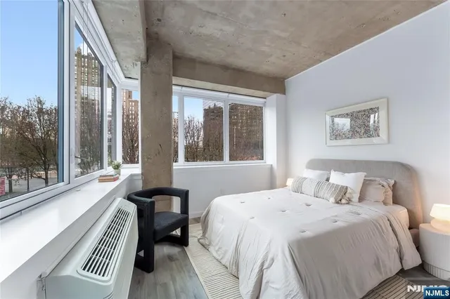 a bedroom with a bed and a large window with outer view