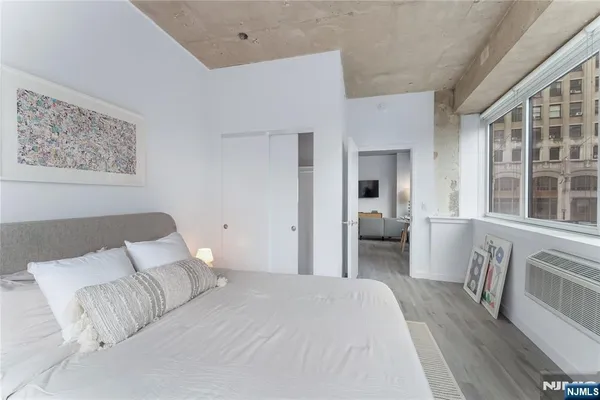 a bedroom with a bed and a large window