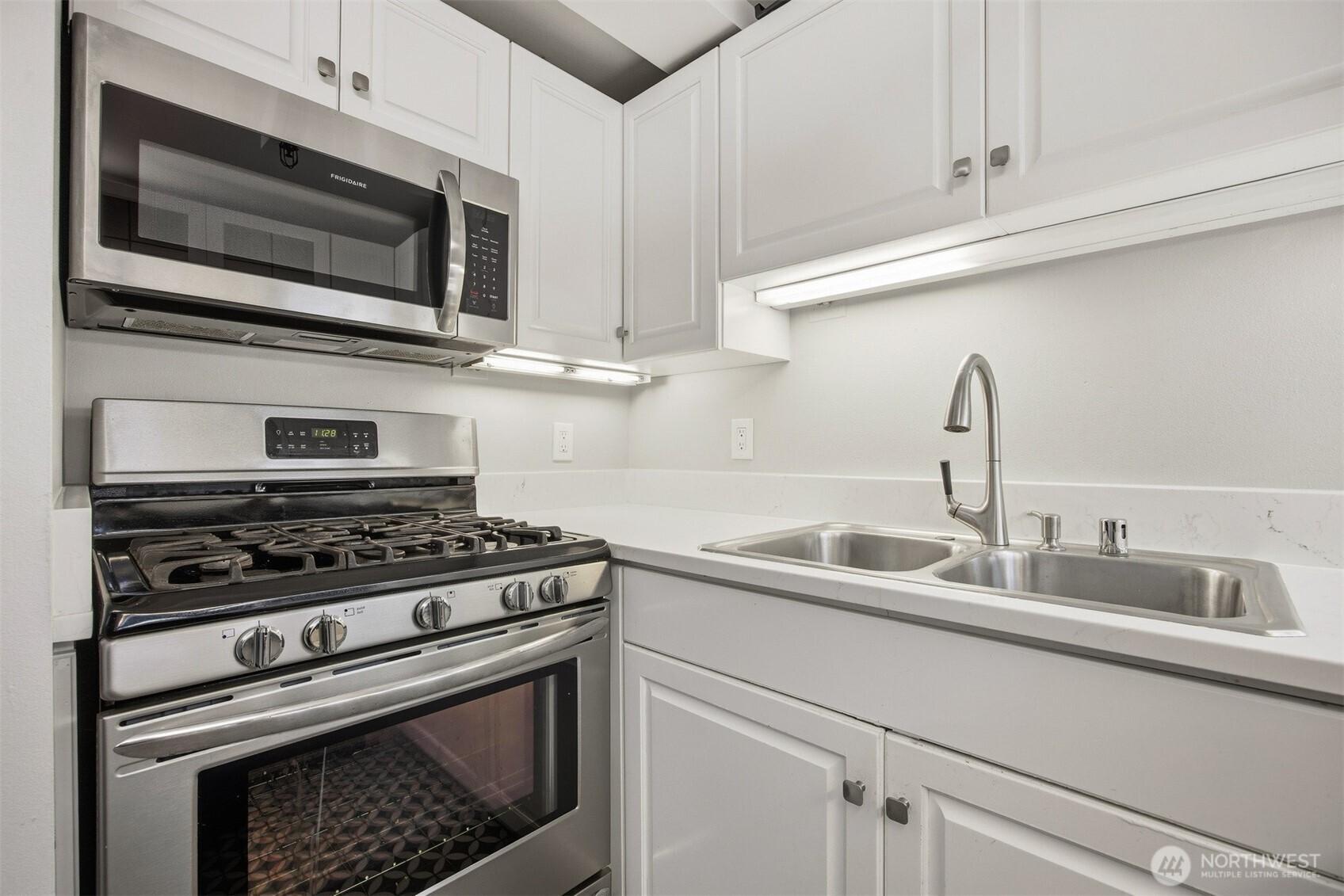 1201 11th Street, Unit 303 Bellingham, WA 98225 - Photo 11 of 34 a kitchen with stainless steel appliances a stove a microwave and sink
