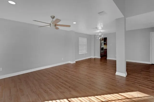 a view of empty room with wooden floor