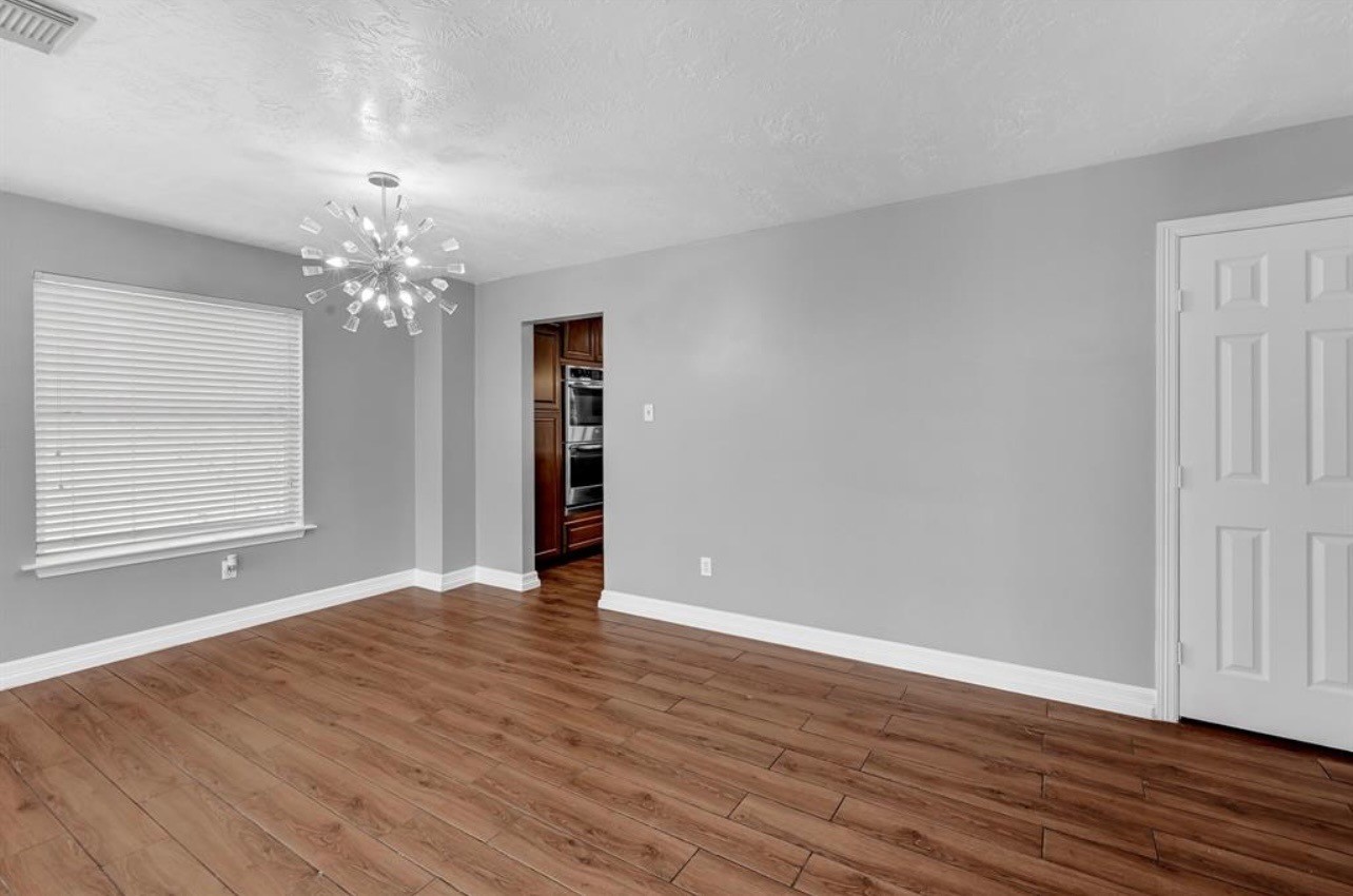 262 Normandy Street Houston, TX 77015 - Photo 7 of 12 a view of an empty room with wooden floor and a window