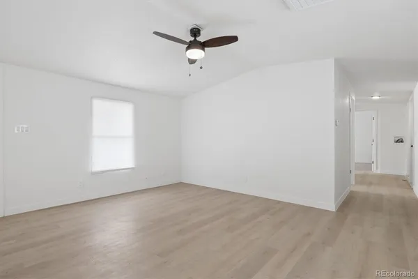 an empty room with a window and a ceiling fan