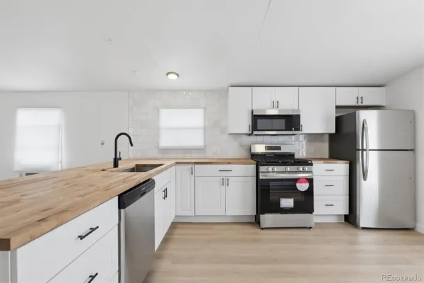 a kitchen with stainless steel appliances granite countertop a refrigerator sink and stove