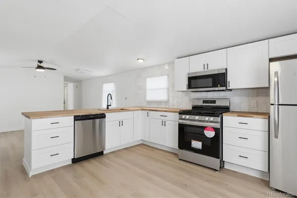 a kitchen with granite countertop a sink stove and refrigerator