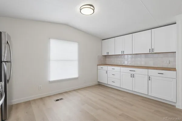 a kitchen with granite countertop white cabinets and white appliances
