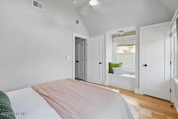 a bedroom with a bed and a wooden floor