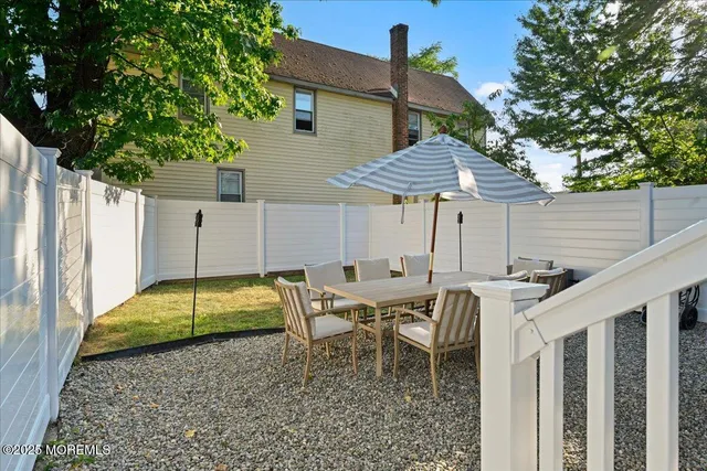 a backyard of a house with table and chairs