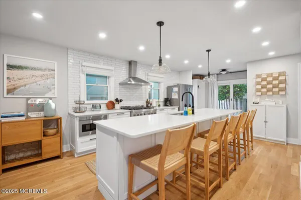 a kitchen with stainless steel appliances kitchen island granite countertop a sink and a refrigerator