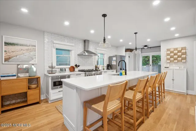 a kitchen with stainless steel appliances kitchen island granite countertop a sink and a refrigerator