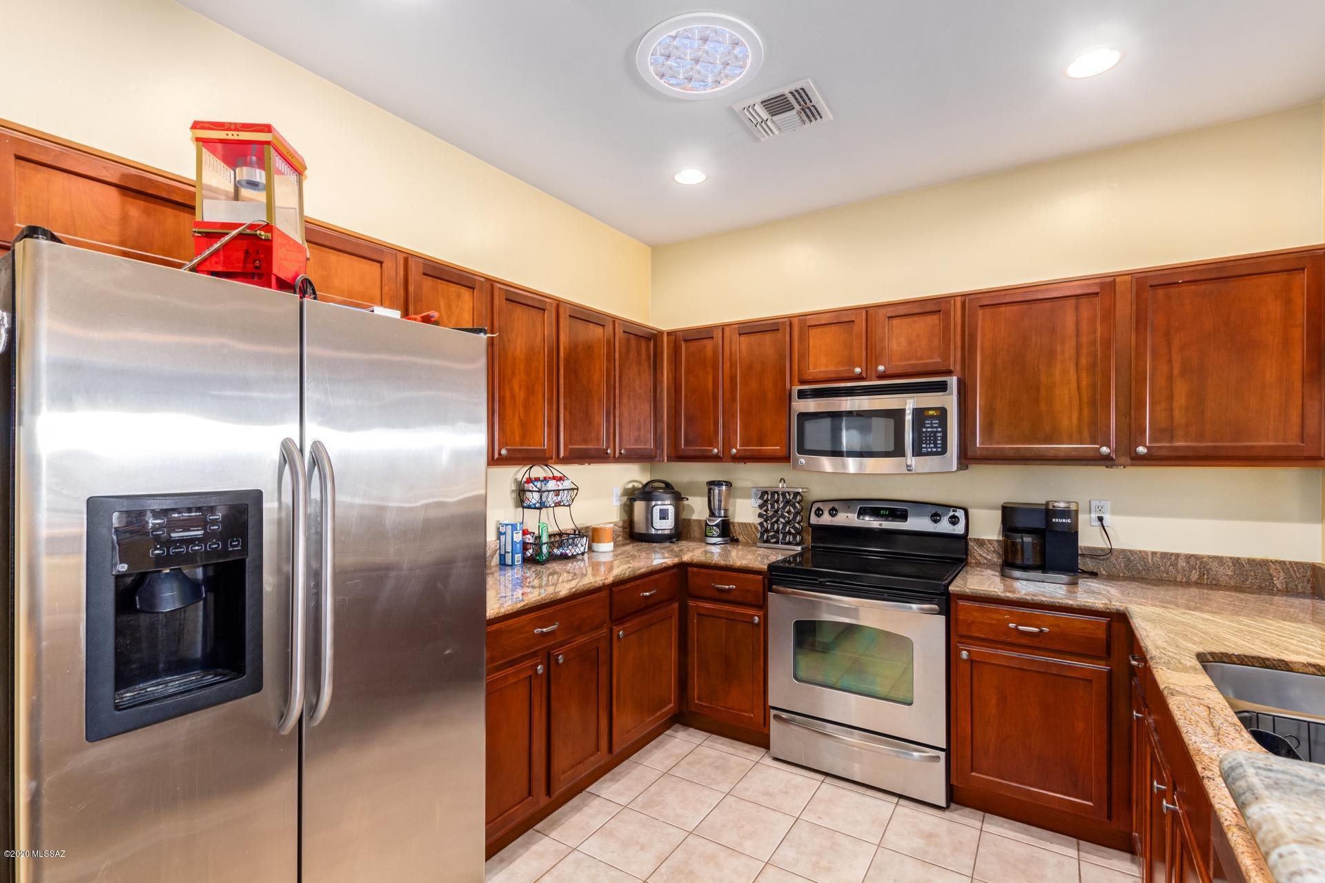 21203 East Reunion Road Red Rock, AZ 85145 - Photo 9 of 26 a kitchen with stainless steel appliances granite countertop a refrigerator a stove and a sink