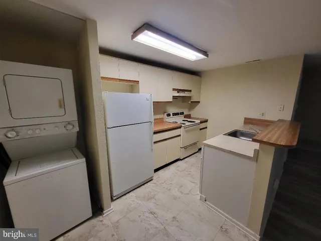 a kitchen with a refrigerator and a washer dryer