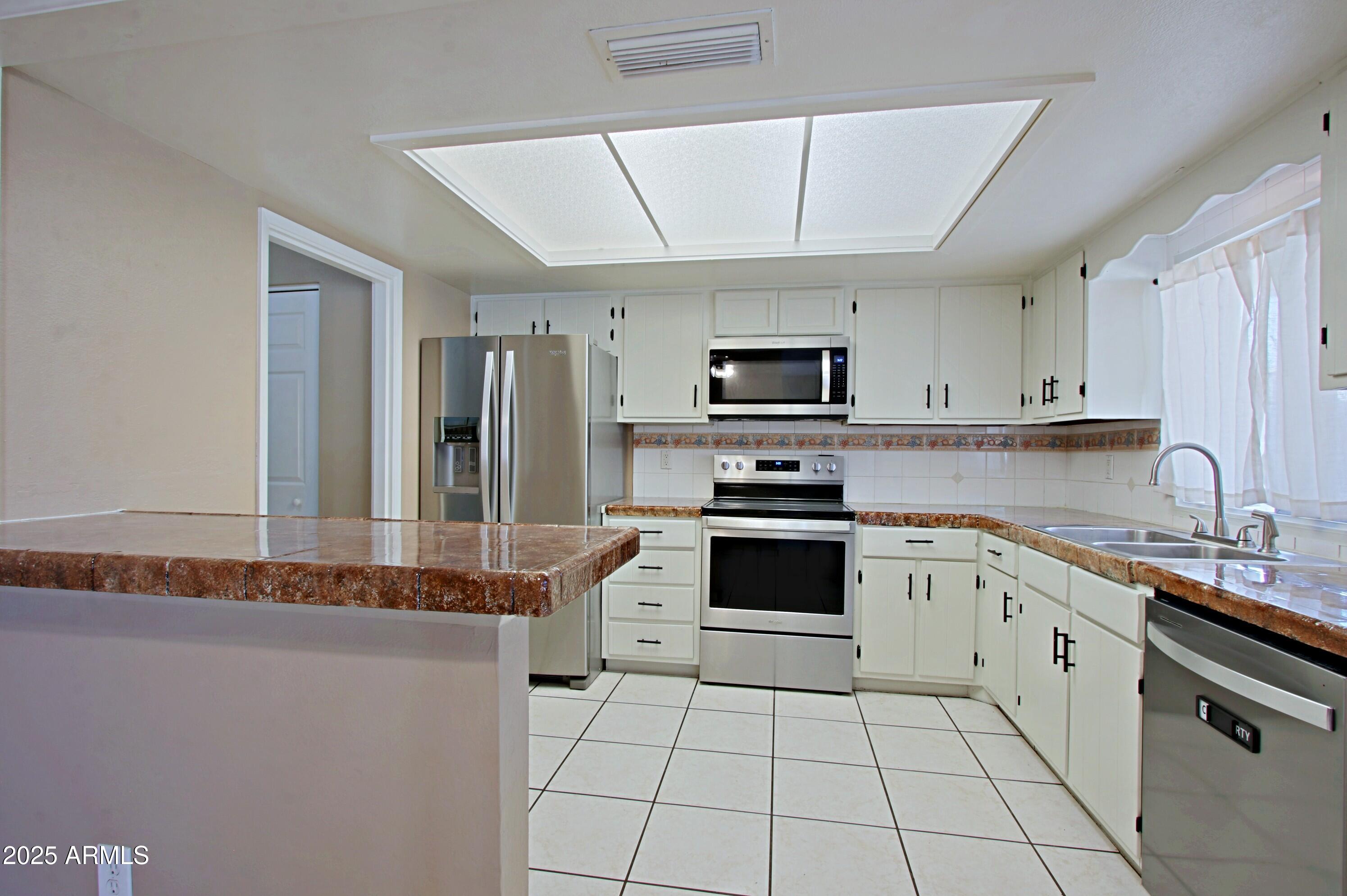 4526 West Altadena Avenue Glendale, AZ 85304 - Photo 7 of 38 a kitchen with granite countertop a sink a counter top space appliances and cabinets