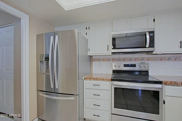 a kitchen with cabinets stainless steel appliances and a counter space