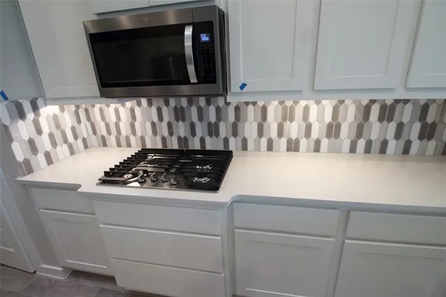 a kitchen with a sink a stove and cabinets
