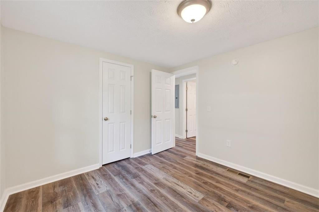 136 Nowell Street Monroe, GA 30655 - Photo 18 of 25 a view of an empty room with wooden floor and a window