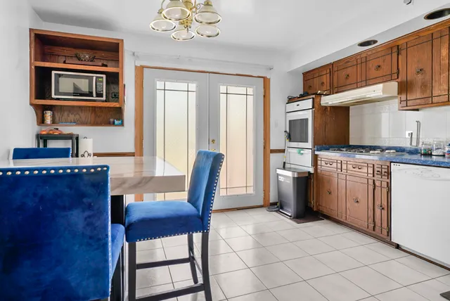 a kitchen with a stove a sink cabinets and a dining table