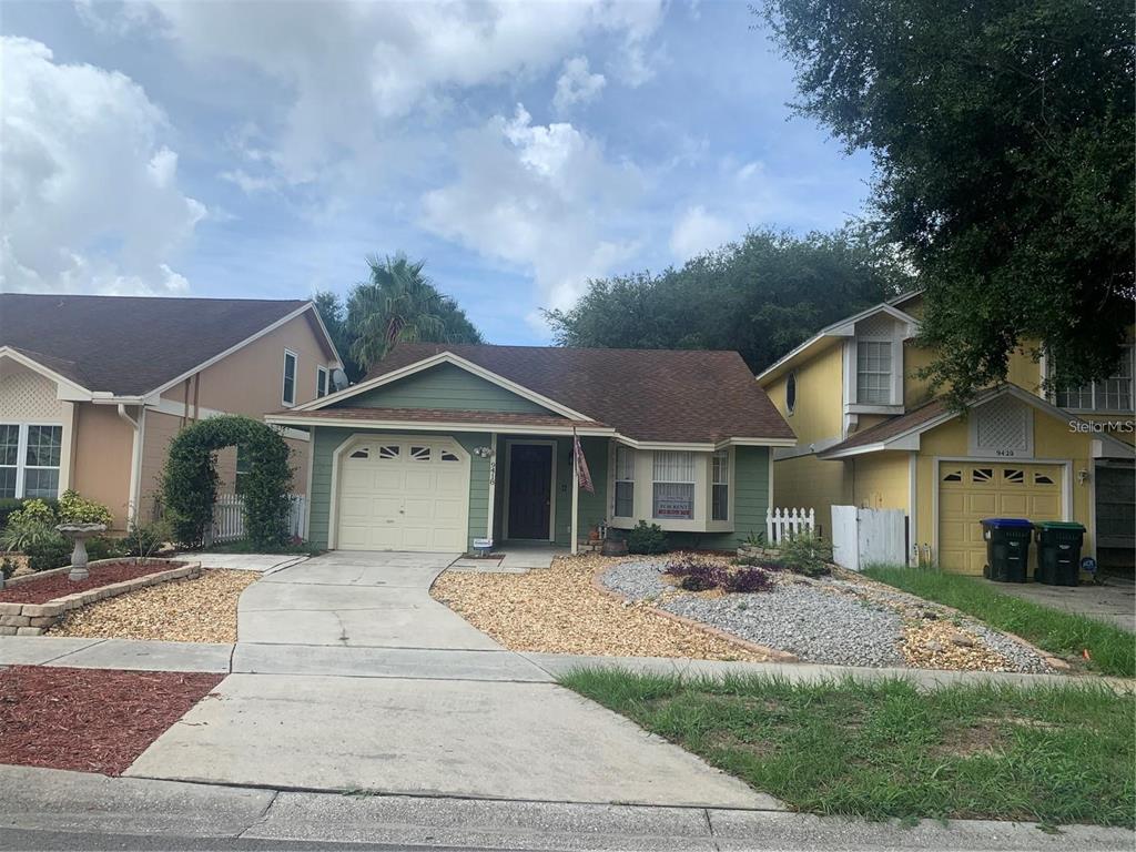a front view of a house with a garden and trees