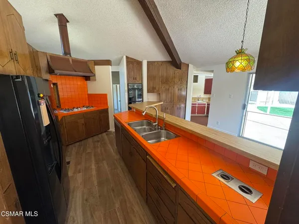 a view of a kitchen with a sink and wooden floor