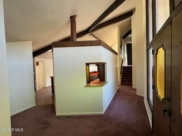 a view of a hallway with wooden floor and stairs