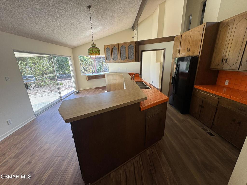 381 Laguna Terrace Simi Valley, CA 93065 - Photo 6 of 48 a kitchen with stainless steel appliances granite countertop a refrigerator a sink dishwasher and wooden cabinets