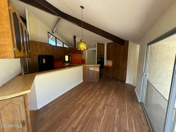 a view of a kitchen with a sink and wooden floor