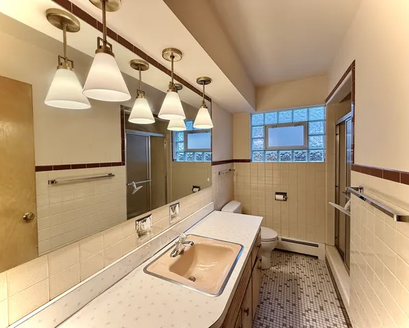 a bathroom with a sink and mirror with bathtub