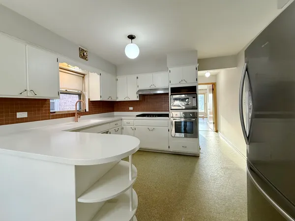 a kitchen with stainless steel appliances a stove a sink refrigerator and cabinets