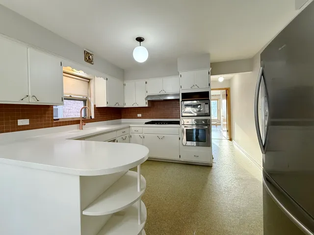 a kitchen with stainless steel appliances a stove a sink refrigerator and cabinets