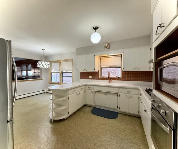 a kitchen that has a lot of cabinets in it and appliances