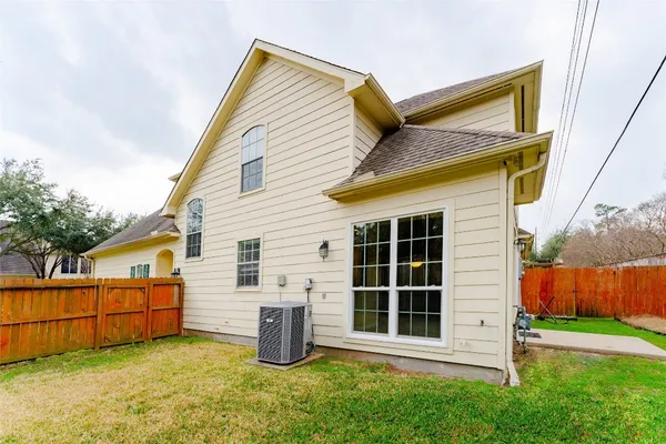 a view of a house with wooden walls and a yard
