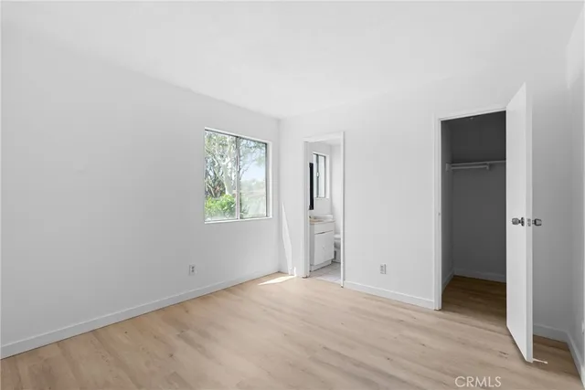 an empty room with wooden floor and window