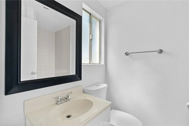 a bathroom with a sink mirror and toilet