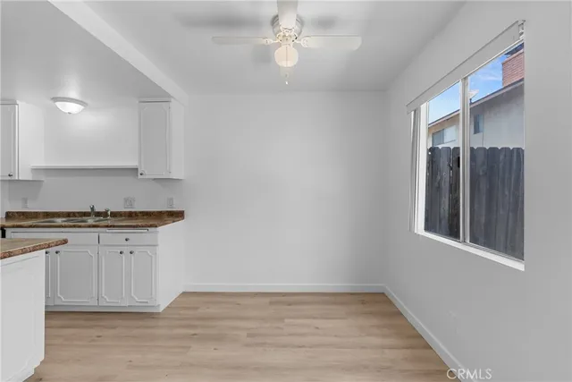 a kitchen with granite countertop white cabinets and black appliances