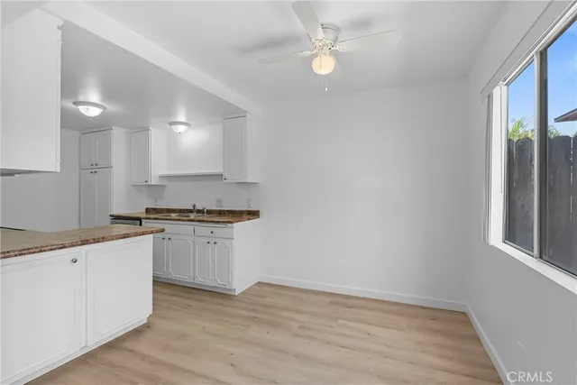 a kitchen with granite countertop white cabinets and appliances